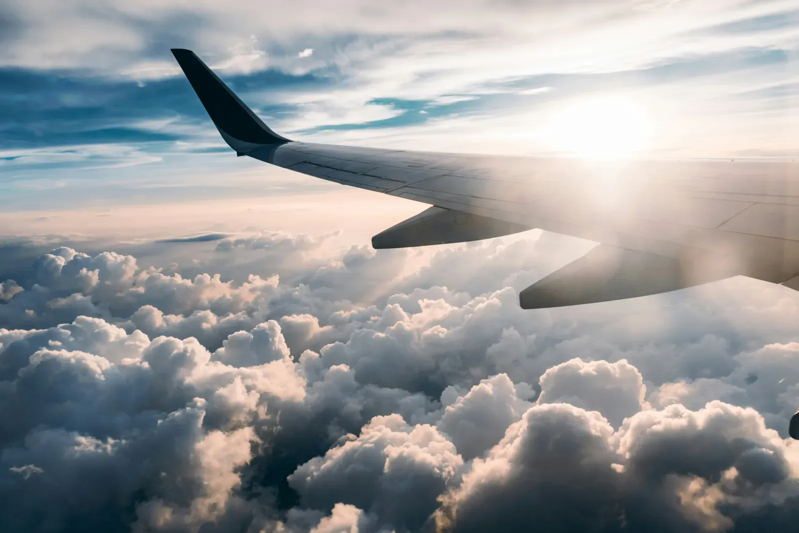 Flugzeugflügel über den Wolken – Symbolbild