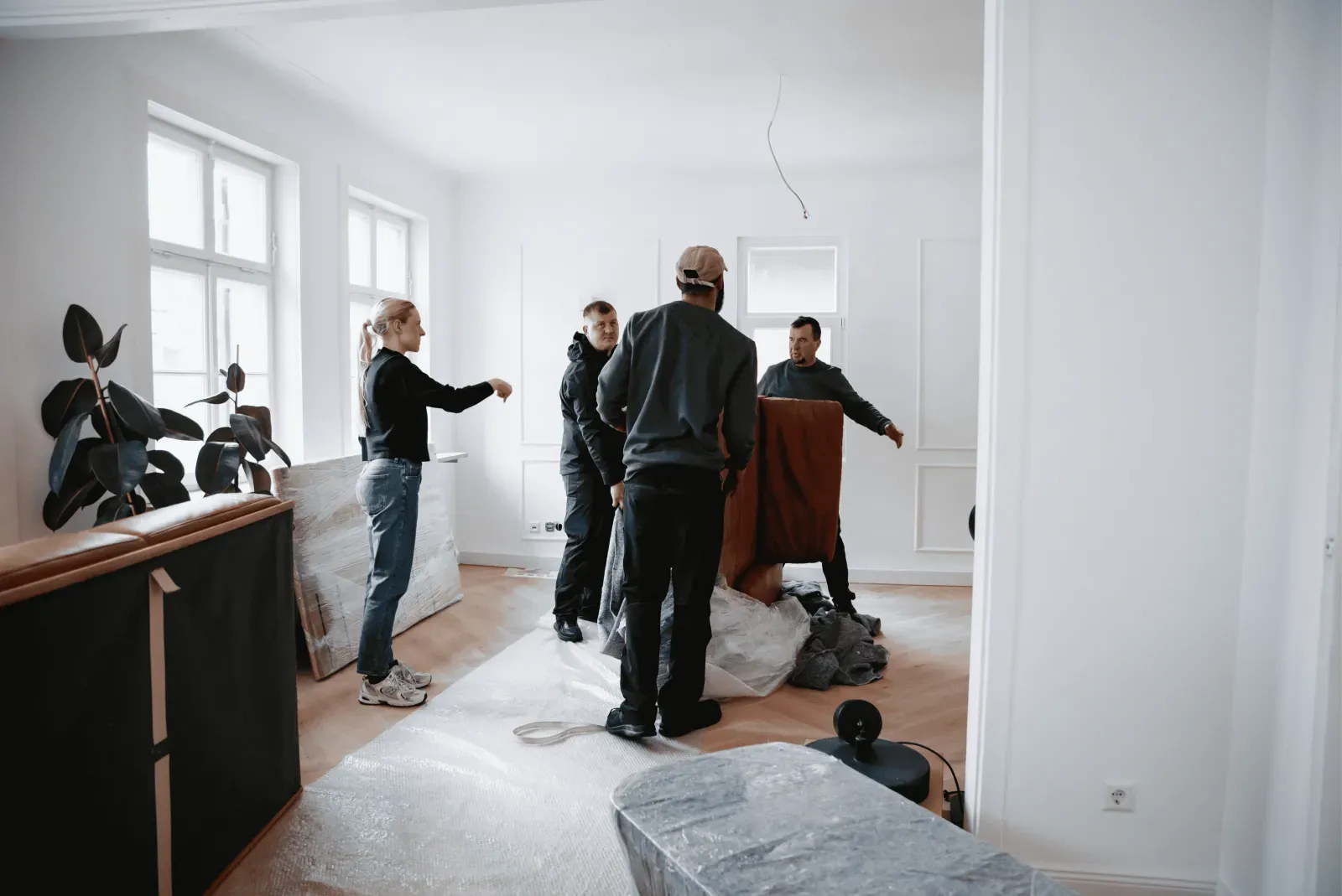 Mehrere Personen bereiten einen Umzug im Wohnraum vor – Symbolbild